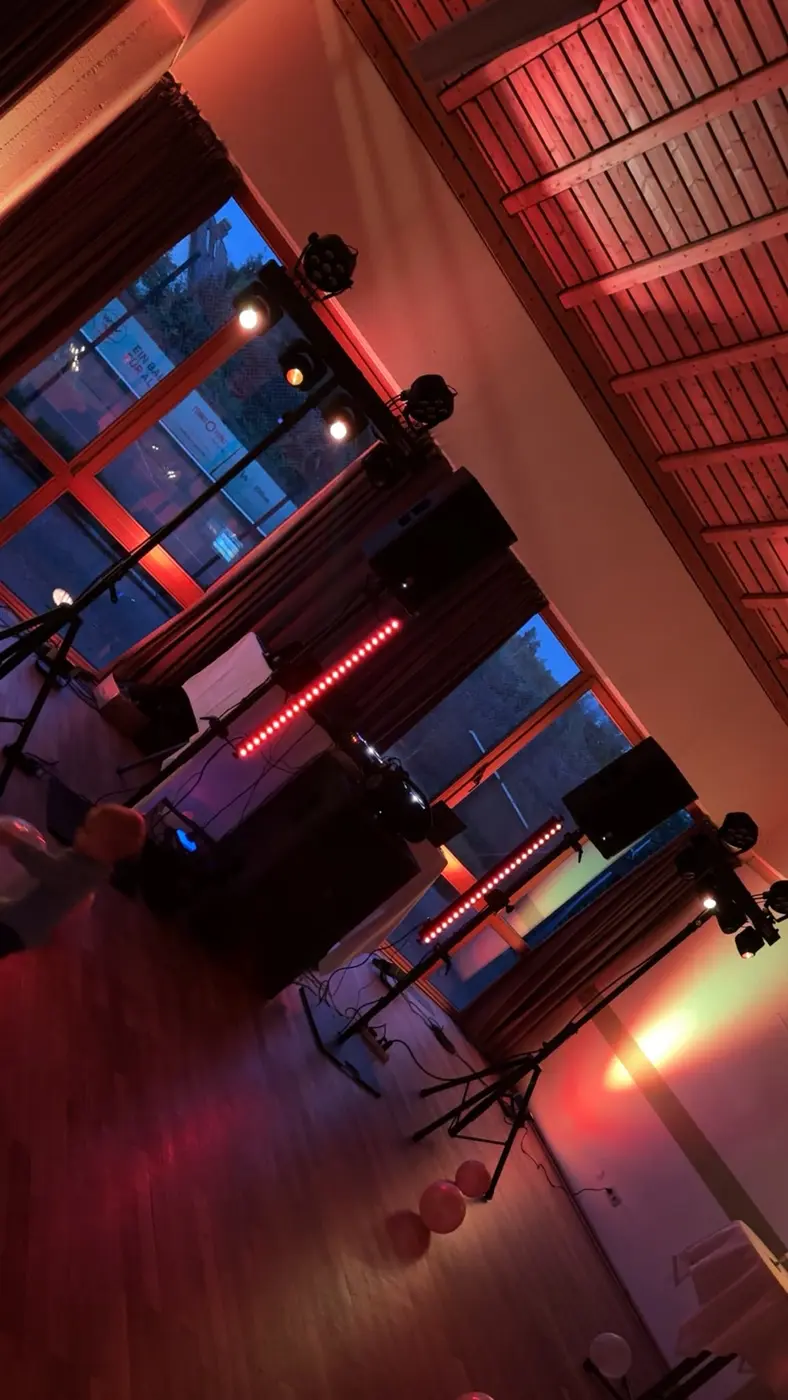 Saal mit roter Traverse und Uplights